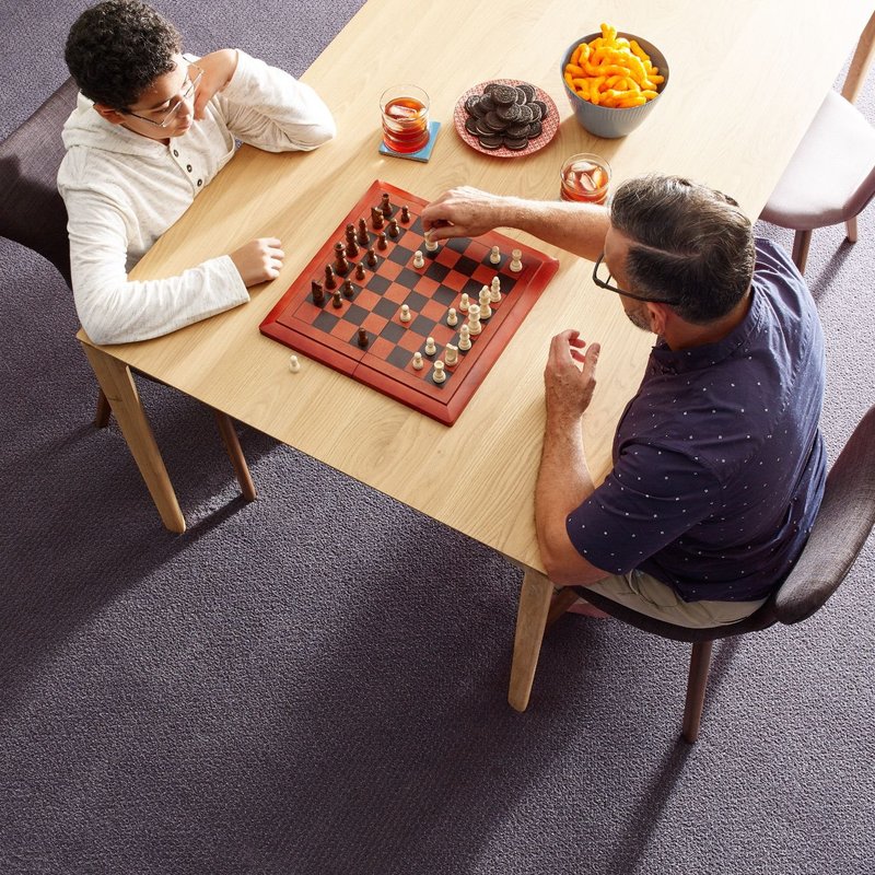 Family Playing Chess At A Dining Room Table